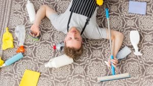 cuidado de alfombras, hombre tirado en el suelo cansado de limpiar su alfombra